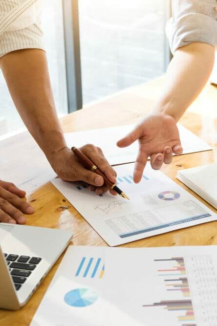 a person pointing at a pen on a paper while discussing one of the 7 free traffic conversion strategies that work.