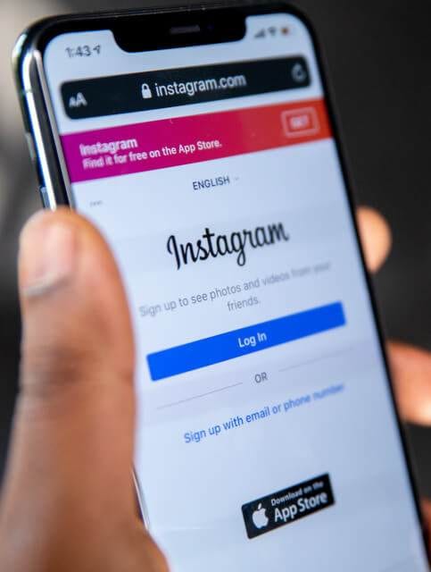 a person holding a smartphone with the instagram app.