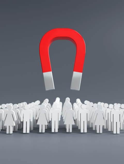 a large red horseshoe magnet hovering above a crowd of white silhouetted figures representing lead generation on a gray background.