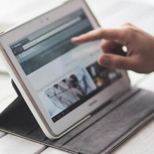a hand pointing at a tablet, demonstrating effective strategies for increasing sales on instagram and facebook.