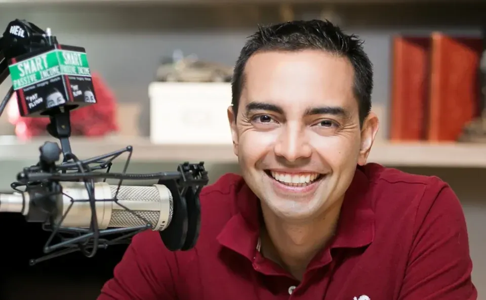 Pat Flynn in a red shirt sits near a microphone labeled 
