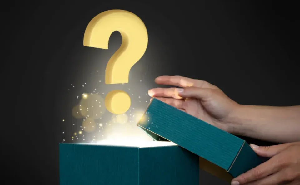 a person's hands are opening a teal gift box emitting light and sparkles, with a large golden question mark hovering above it, reminiscent of the excitement found in women's magazines.