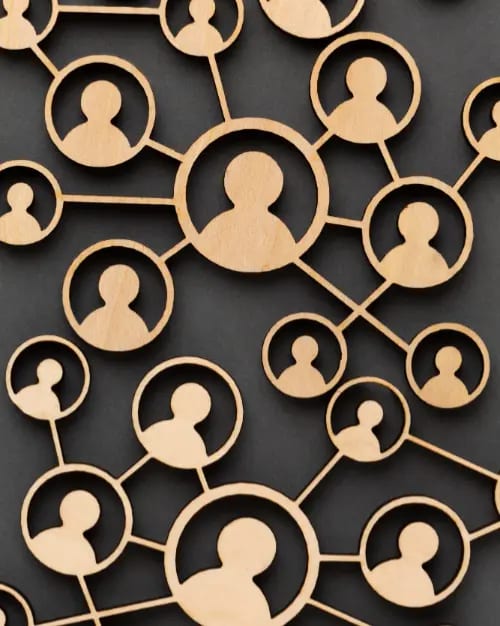 a wooden network of connected human figures on a dark background symbolizes communication strategies and social connections.