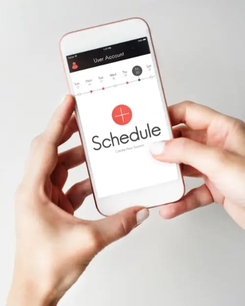 person holding a smartphone with a scheduling app open, displaying a "schedule" screen and options to add new sessions for specific days of the week. ideal for those mastering continuity programs and looking to manage sustainable income streams efficiently.